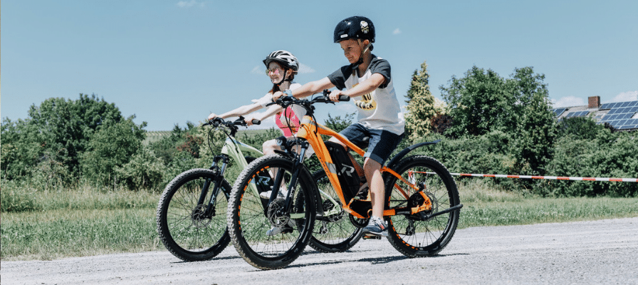Zwei Kinder auf e-Mountainbikes